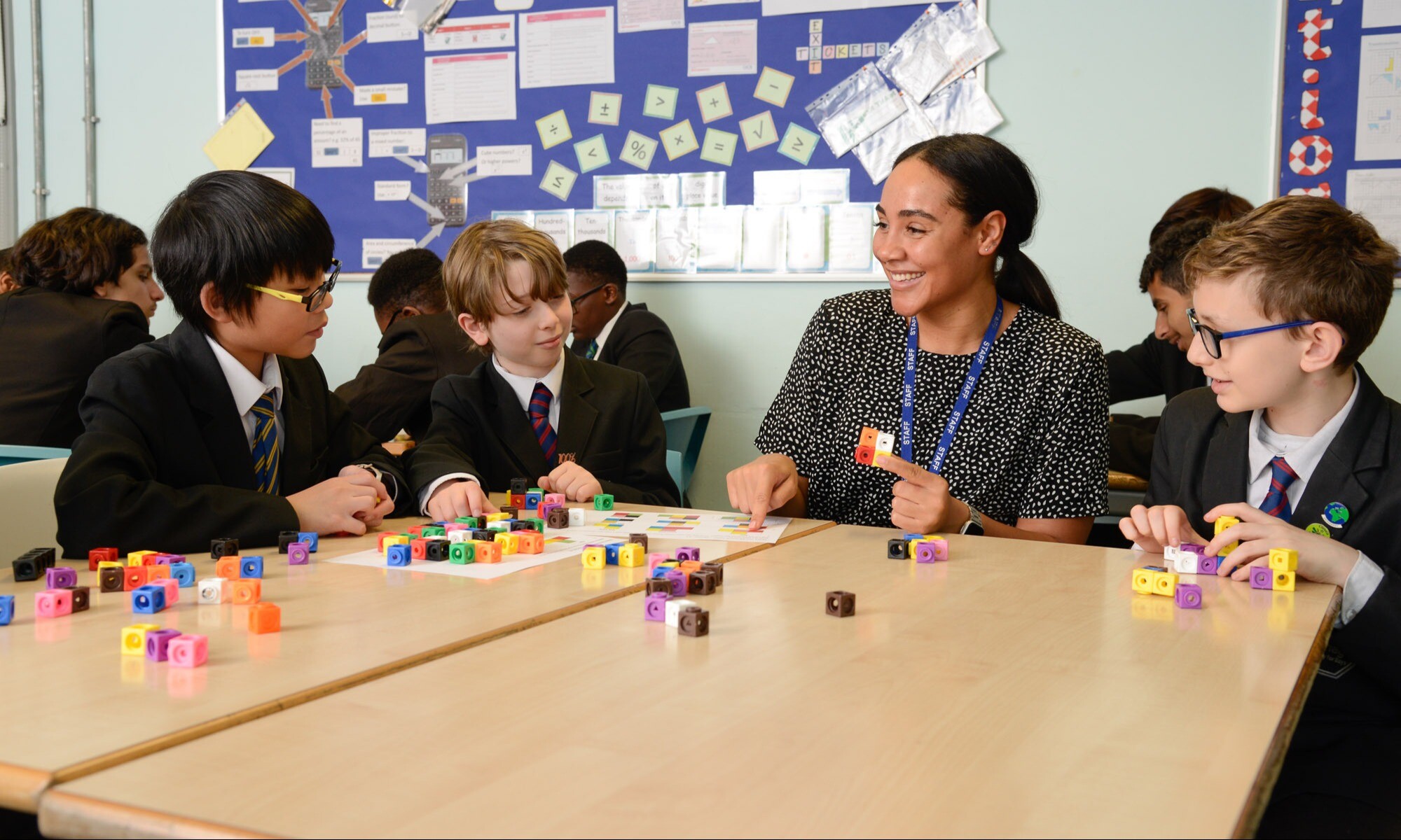 A Maths teacher talking with a young group of students